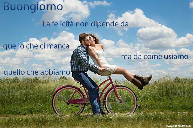 Una coppia felice che va in bicicletta sotto un cielo azzurro