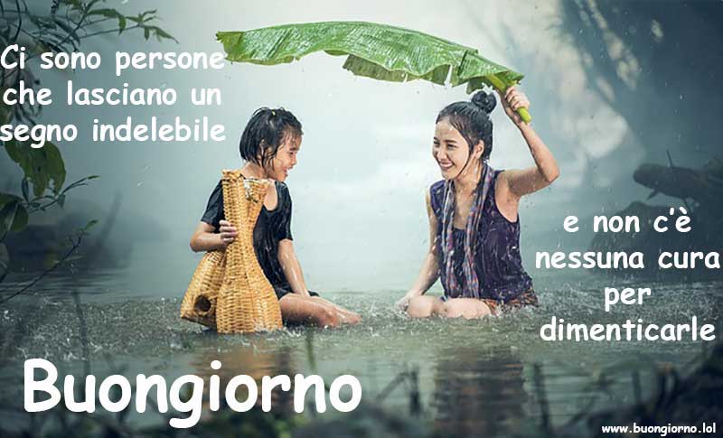 Una madre protegge sua figlia dalla pioggia con un foglia gigante